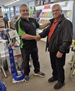 Brothers Richard and Rheal re-enact the passing of the Pellerin Paints family business baton.